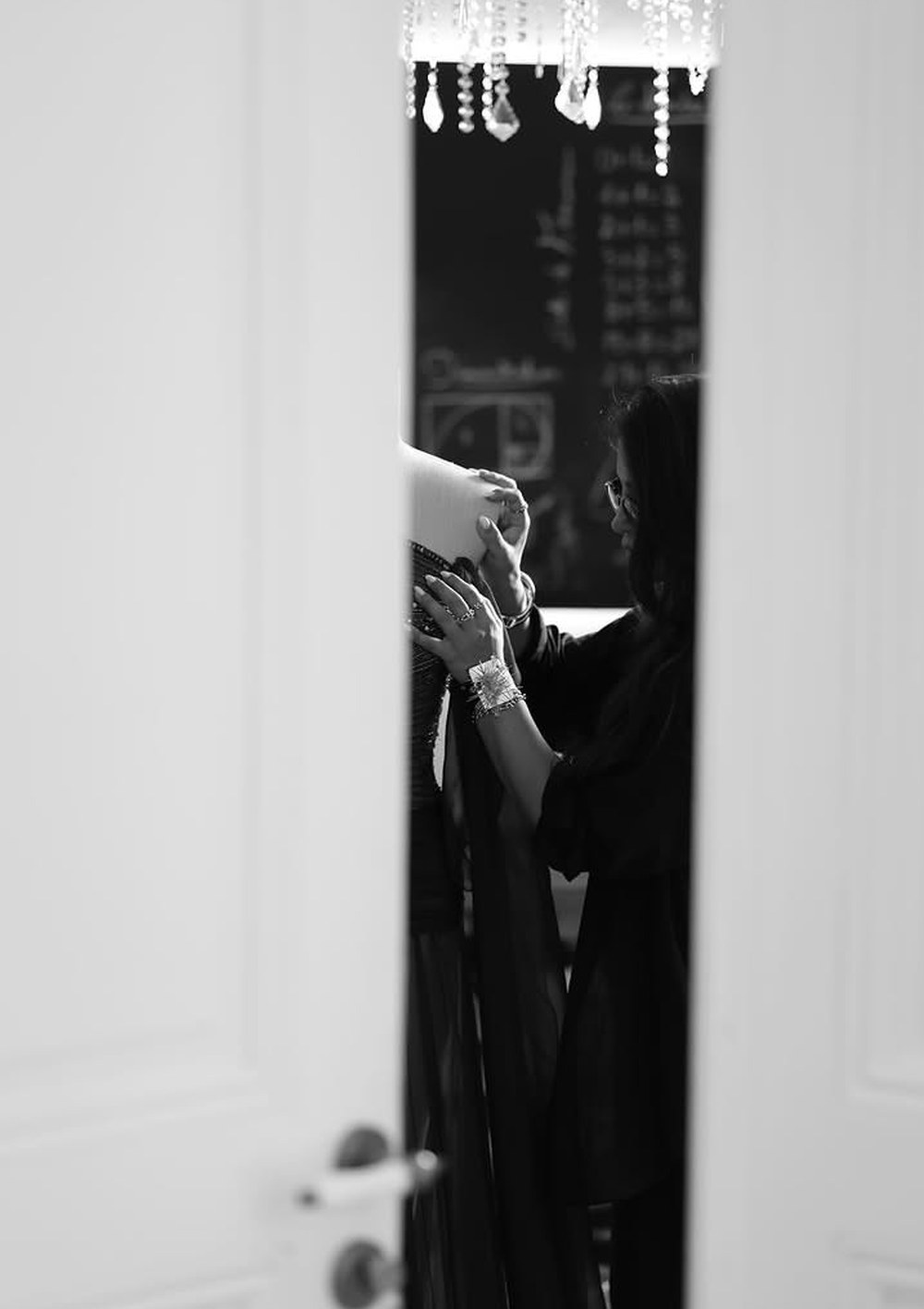 Jessy Abi Nader shaping a gown in the atelier, the mathematical board behind her
